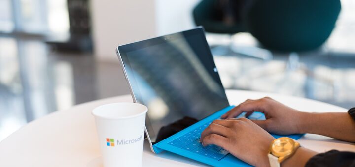 person-working-on-surface-device-microsoft-cup