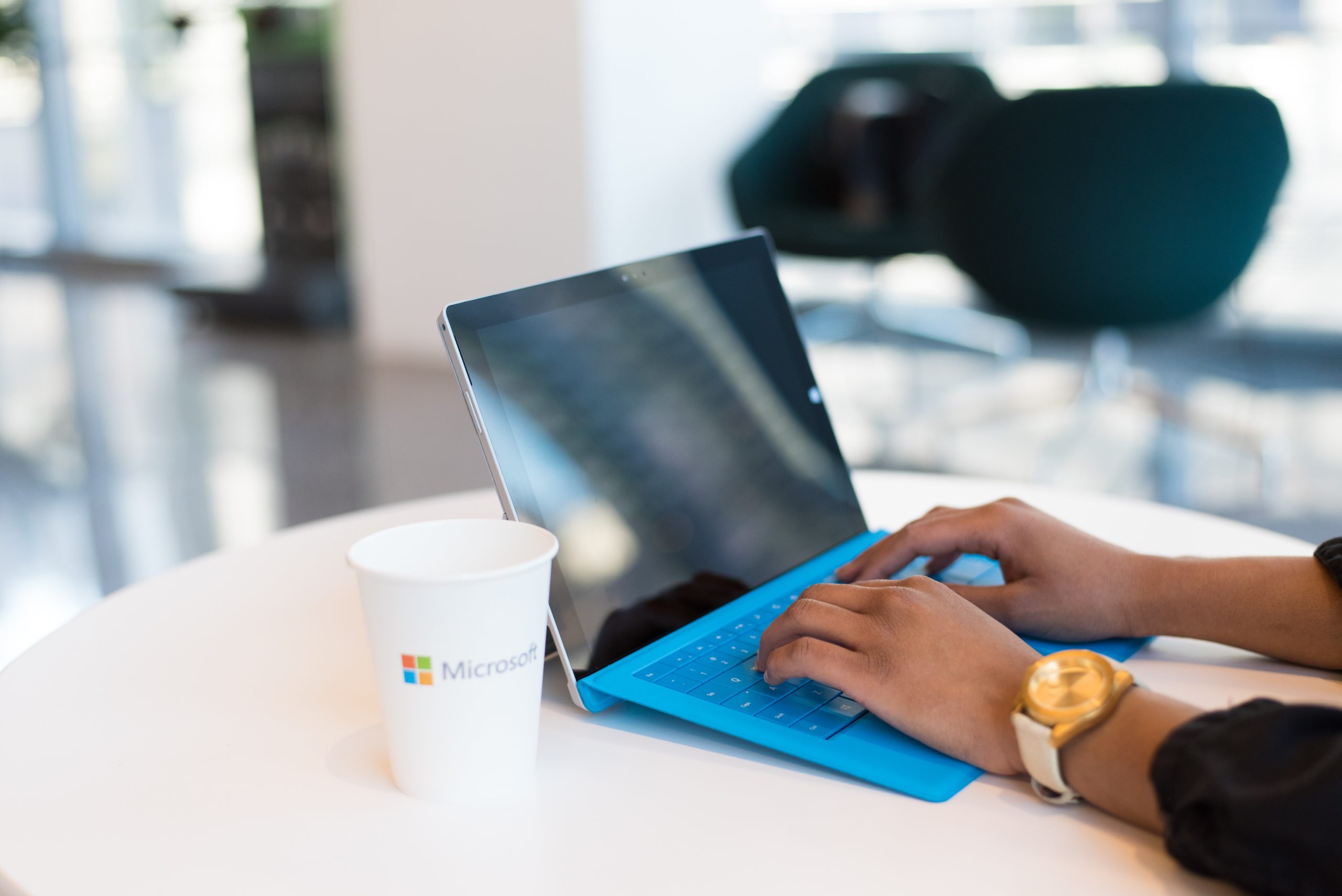 person-working-on-surface-device-microsoft-cup